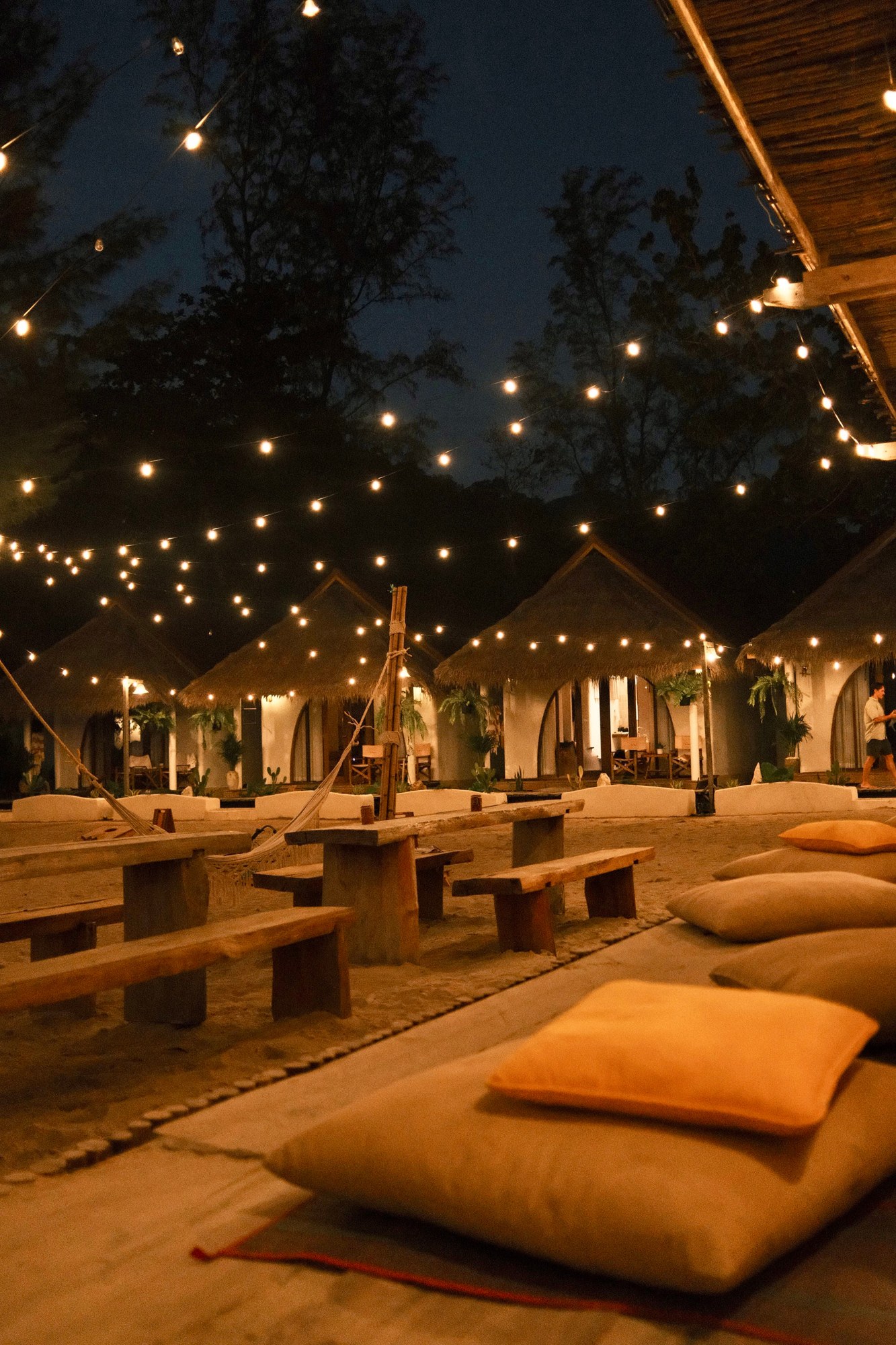 Beach bungalows lit with festoon lights at night