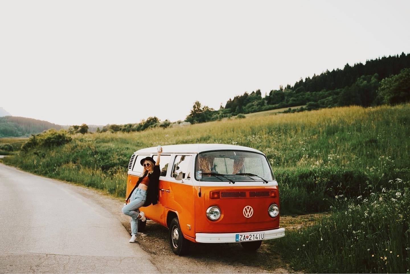 Simona beside a vintage camper van on a country road